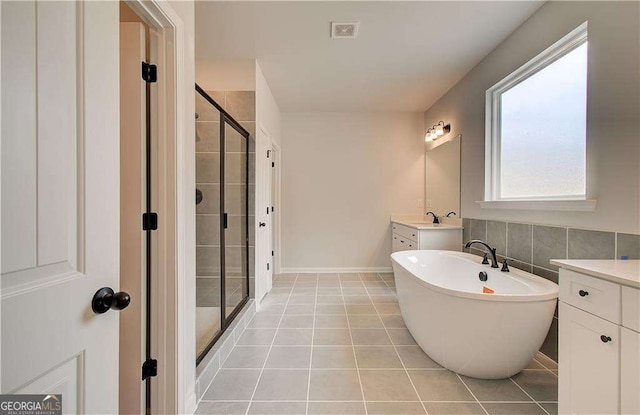 bathroom featuring vanity, plus walk in shower, and tile patterned flooring