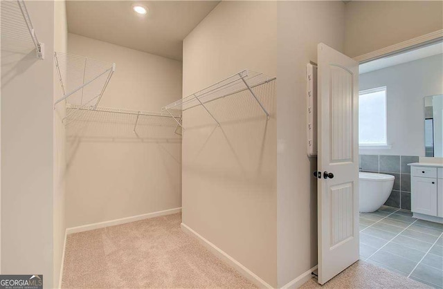 walk in closet with light tile patterned floors