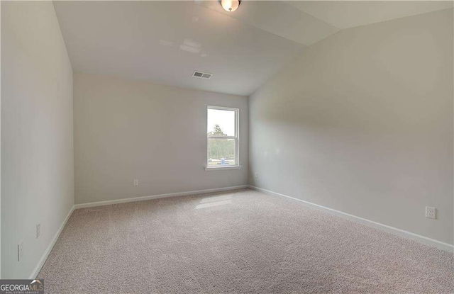 unfurnished room featuring vaulted ceiling and carpet