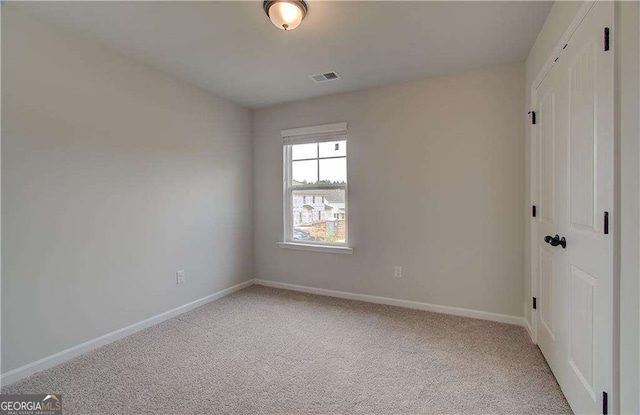 unfurnished room featuring light carpet