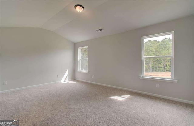 empty room featuring lofted ceiling and carpet flooring