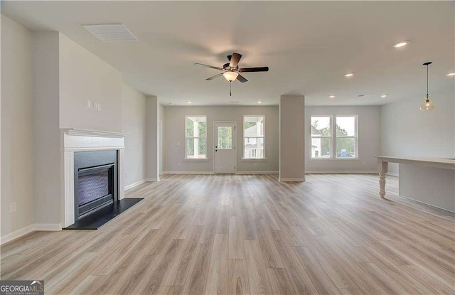 unfurnished living room featuring ceiling fan and light hardwood / wood-style floors