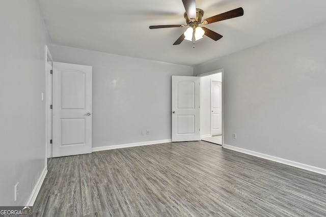 unfurnished room with dark hardwood / wood-style flooring and ceiling fan