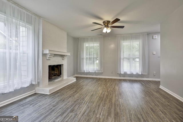 unfurnished living room with a fireplace, dark wood-type flooring, and ceiling fan