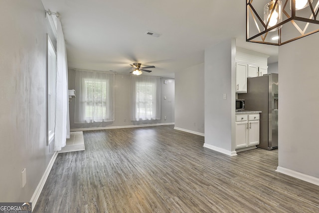 unfurnished living room with dark hardwood / wood-style floors and ceiling fan