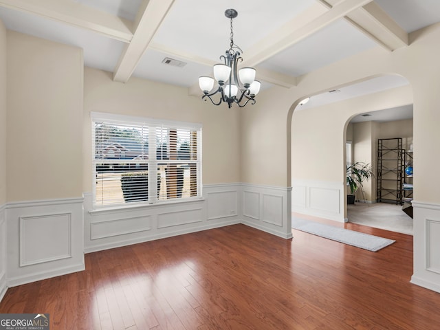 unfurnished dining area featuring hardwood / wood-style flooring, an inviting chandelier, and beam ceiling