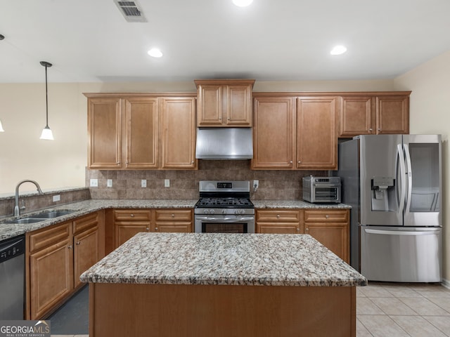 kitchen featuring appliances with stainless steel finishes, decorative light fixtures, sink, light tile patterned floors, and light stone countertops