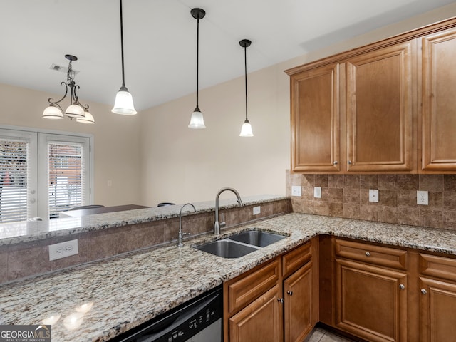 kitchen with stainless steel dishwasher, light stone countertops, sink, and hanging light fixtures