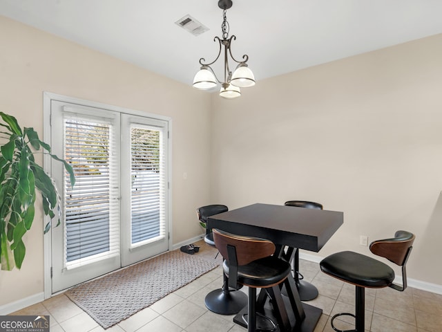 dining area with light tile patterned floors and a notable chandelier