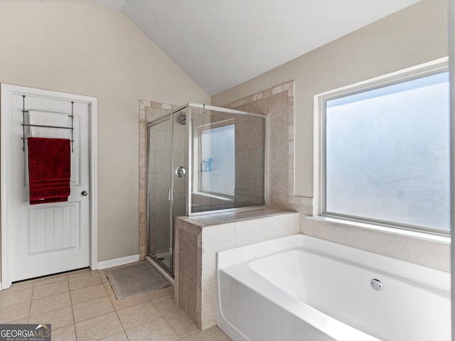 bathroom with plus walk in shower, lofted ceiling, and tile patterned floors