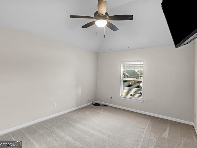 empty room featuring vaulted ceiling, light colored carpet, and ceiling fan