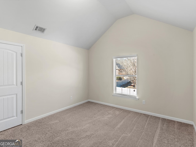 carpeted empty room with lofted ceiling