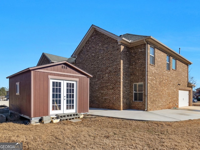 back of house featuring french doors, a garage, and a yard