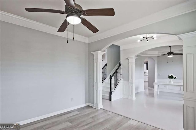 spare room featuring ornamental molding, light hardwood / wood-style floors, and decorative columns