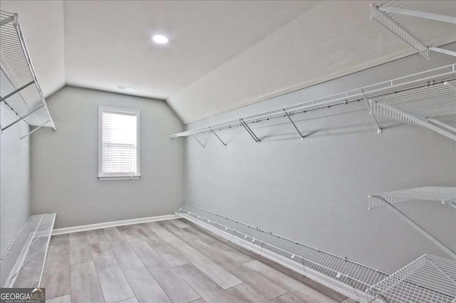 spacious closet featuring vaulted ceiling and light hardwood / wood-style floors