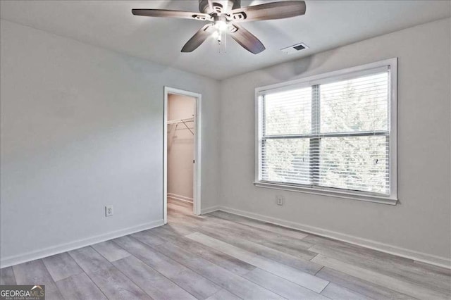 empty room with light hardwood / wood-style flooring and ceiling fan