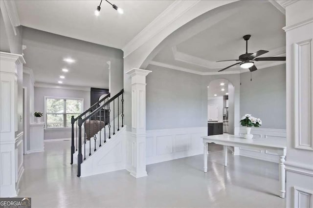 stairway with ornamental molding, ceiling fan, and ornate columns