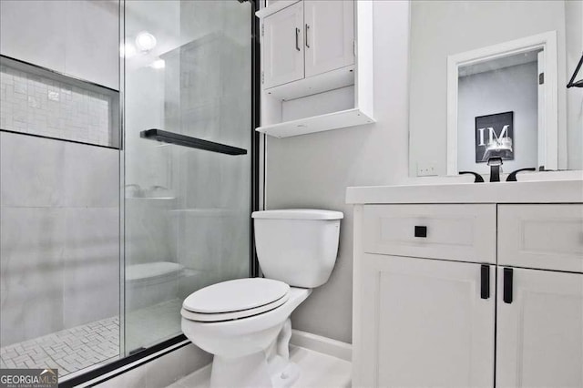 bathroom with vanity, a shower with door, and toilet