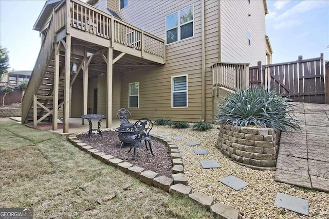 rear view of house featuring a wooden deck, a fire pit, and a patio