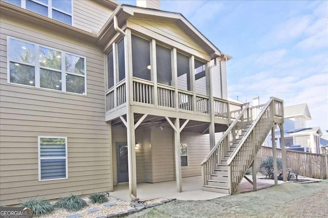 rear view of property featuring a patio and a sunroom