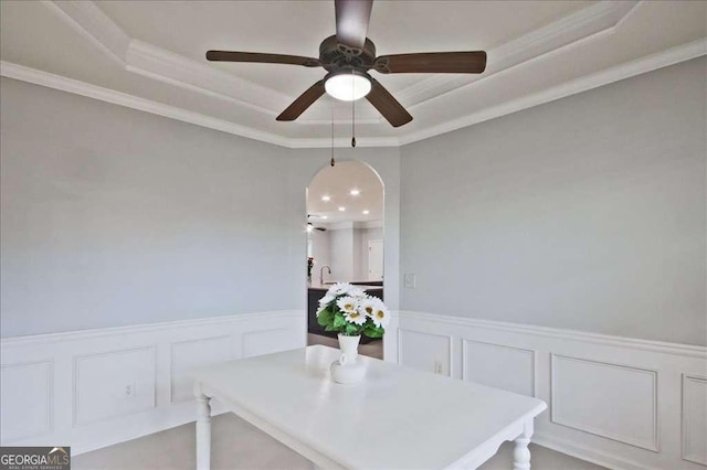 dining room with crown molding, sink, ceiling fan, and a tray ceiling