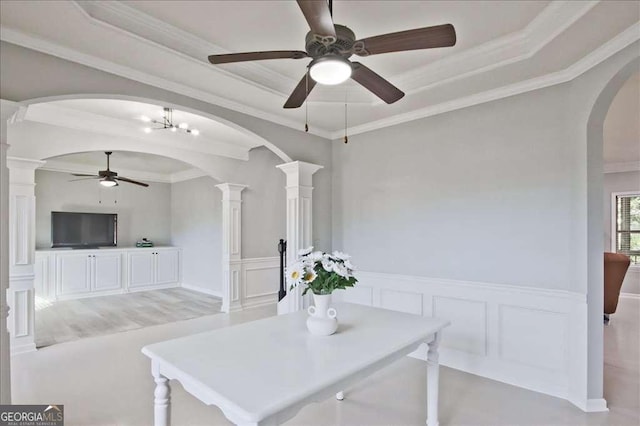 dining space featuring ornamental molding, a raised ceiling, and ornate columns