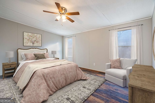 bedroom featuring dark wood-type flooring, ceiling fan, crown molding, and multiple windows