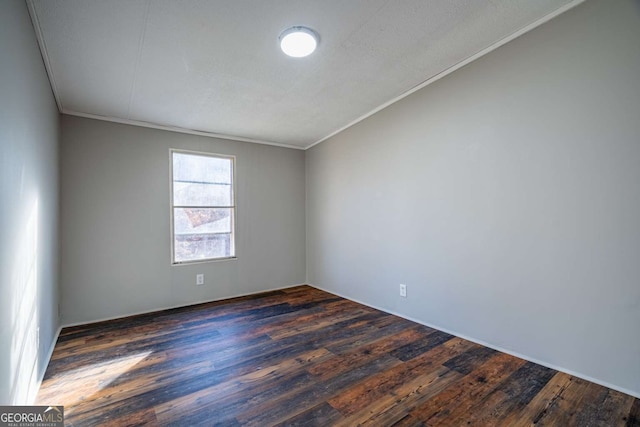 spare room featuring ornamental molding and dark wood-type flooring