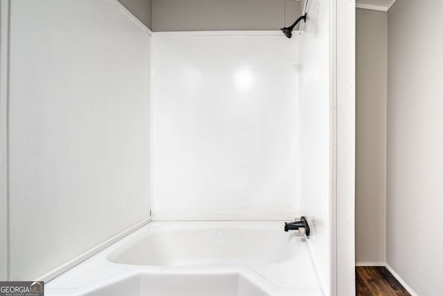 bathroom with hardwood / wood-style floors and a washtub