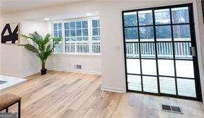 interior space featuring ceiling fan, light hardwood / wood-style floors, and vaulted ceiling with beams