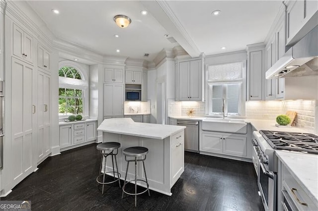 kitchen featuring sink, stainless steel appliances, a center island, and white cabinets