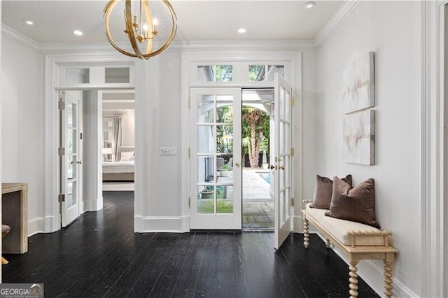 doorway featuring french doors, crown molding, a chandelier, and dark wood-type flooring