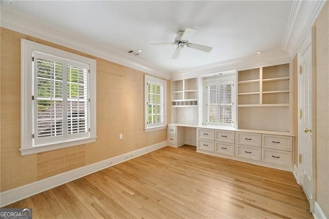 unfurnished bedroom featuring light wood-style flooring, multiple windows, ornamental molding, and baseboards