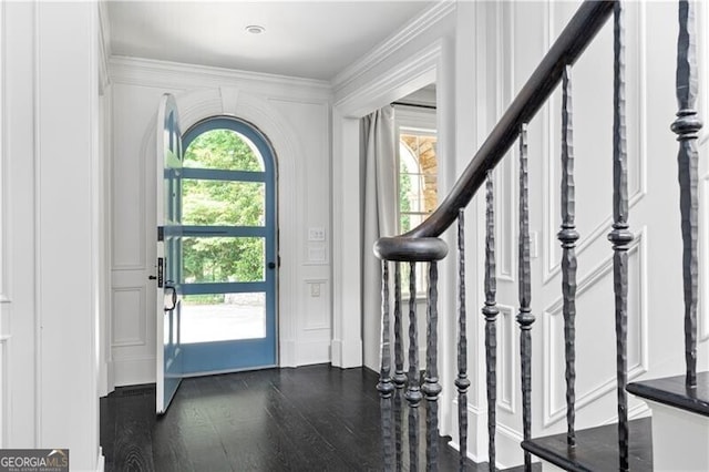 foyer entrance with crown molding and dark wood-type flooring