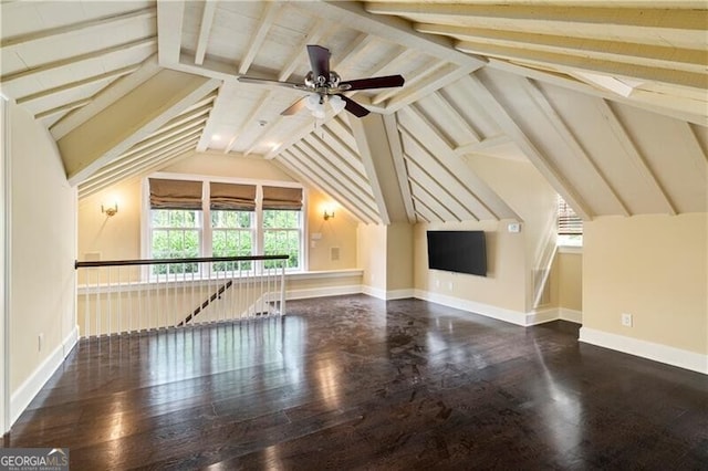 additional living space with ceiling fan, dark hardwood / wood-style flooring, and lofted ceiling with beams