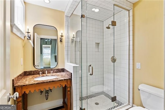 bathroom with sink, an enclosed shower, and toilet