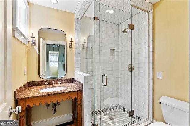 full bath featuring toilet, a stall shower, and vanity