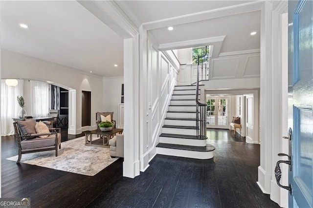 foyer entrance with ornamental molding, dark hardwood / wood-style floors, and a healthy amount of sunlight