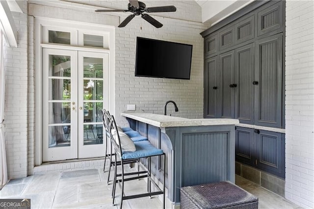 view of patio / terrace with outdoor dry bar, french doors, and ceiling fan