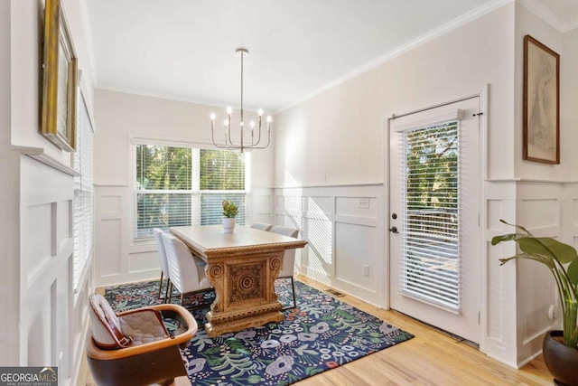 dining area featuring plenty of natural light, ornamental molding, and light wood-type flooring