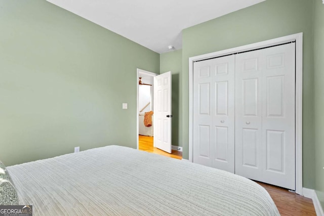 bedroom with light hardwood / wood-style floors and a closet