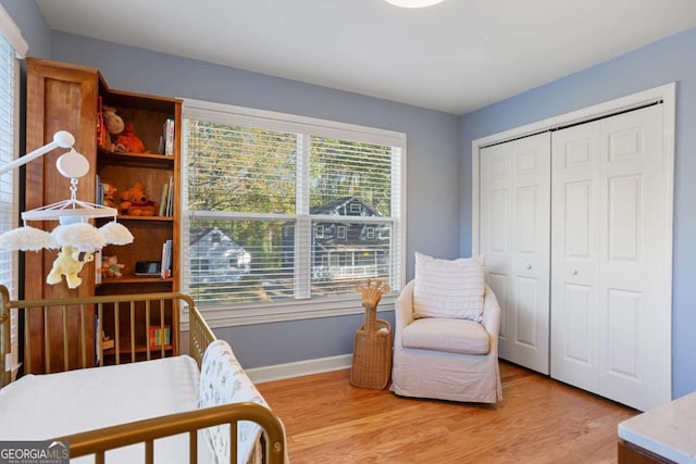 bedroom with light hardwood / wood-style flooring and a closet