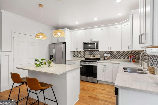 kitchen featuring sink, stainless steel appliances, white cabinets, and a kitchen island