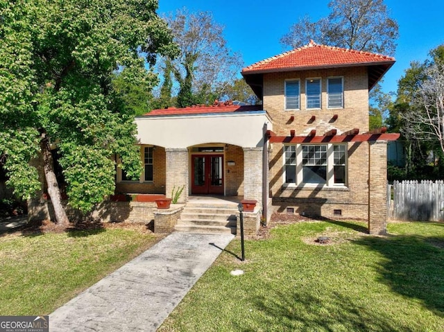 mediterranean / spanish home featuring a front yard and french doors