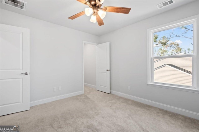 carpeted spare room with ceiling fan