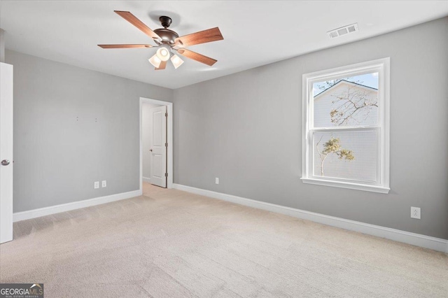 spare room with light colored carpet and ceiling fan