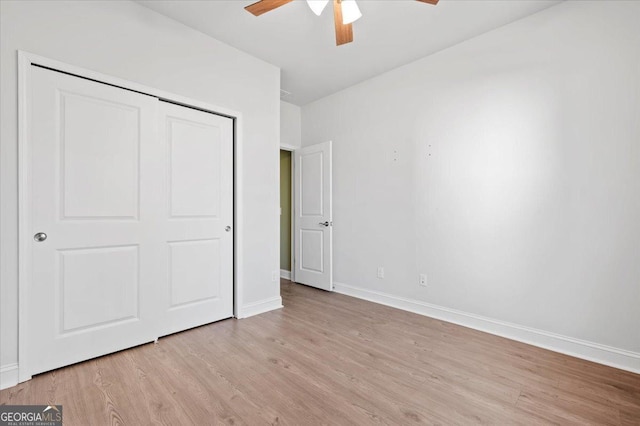 unfurnished bedroom featuring ceiling fan, a closet, and light wood-type flooring