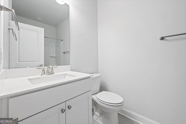 bathroom featuring vanity, walk in shower, and toilet