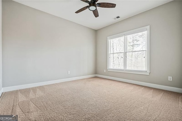 spare room featuring carpet floors, visible vents, baseboards, and a ceiling fan