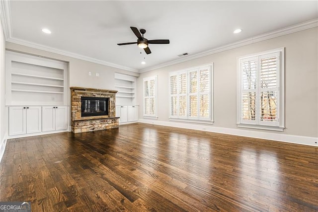 unfurnished living room with built in shelves, a fireplace, ornamental molding, wood finished floors, and baseboards